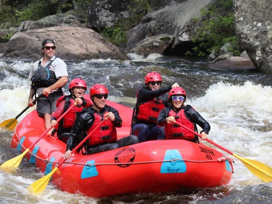 North Creek rafting participants wearing helmets and life jackets with their guide