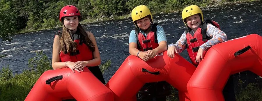 Guests with red river tubes, helmets and life jackets, from North Creek’s website